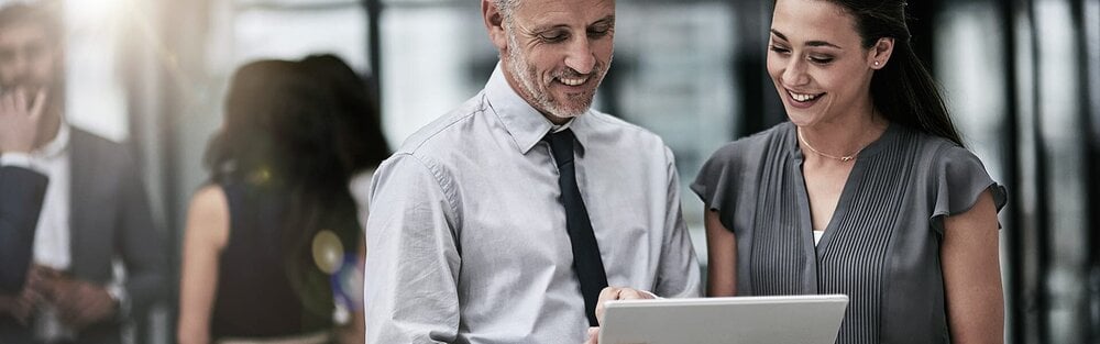 Zwei Personen schauen gemeinsam auf ein Tablet.